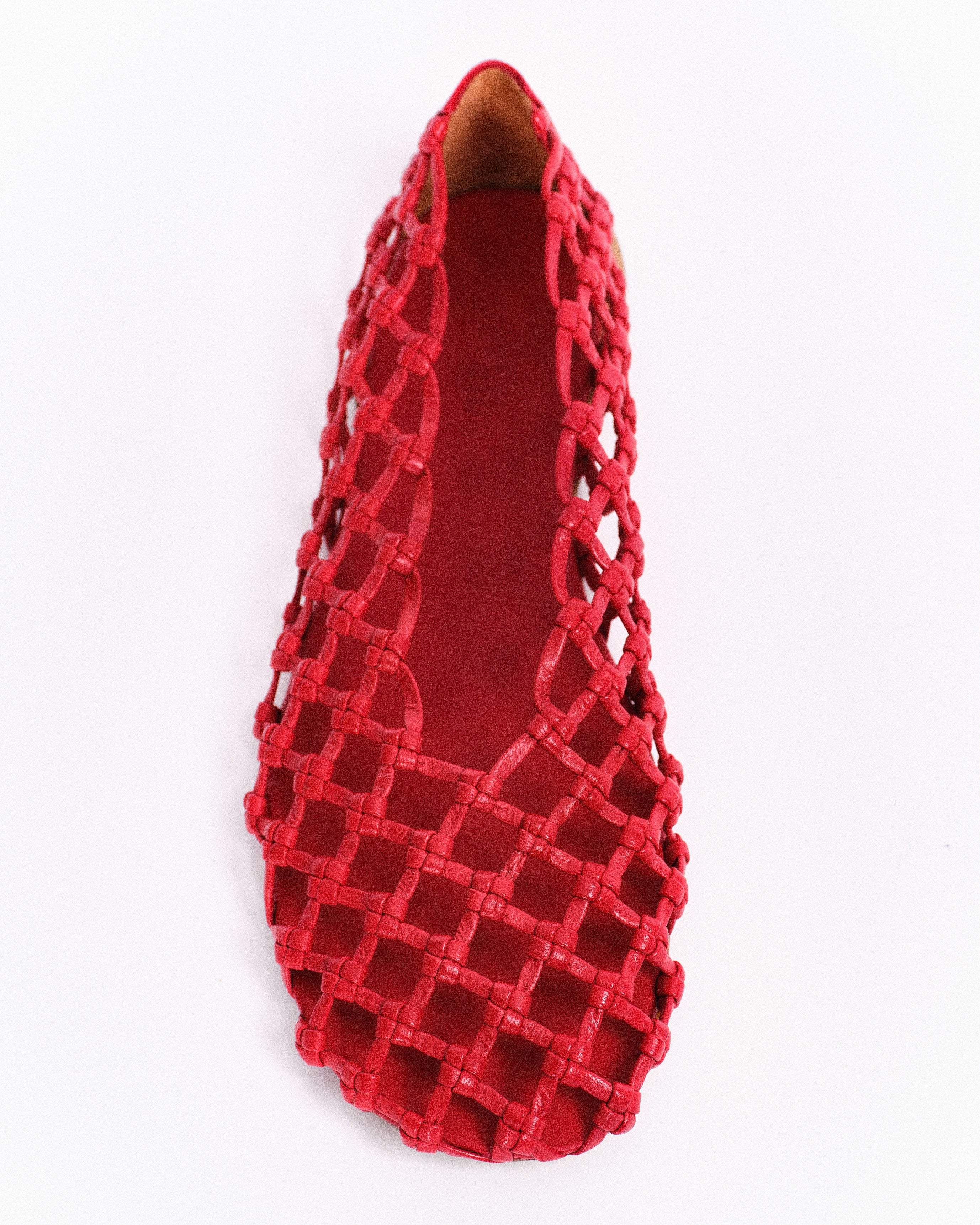 Red woven barefoot shoe on a white background